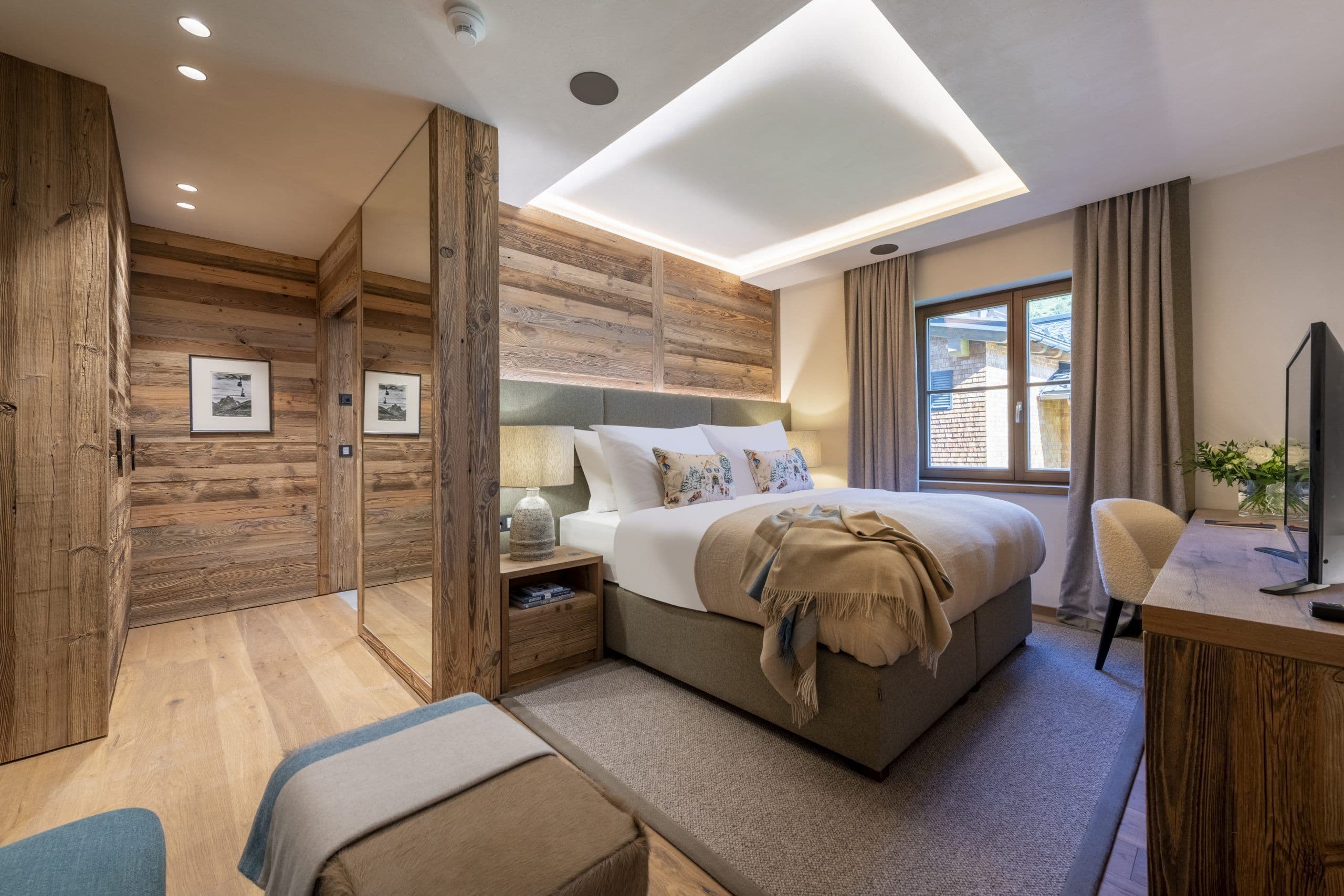 Chalech S guest bedroom with warm wood panelling and cove lighting, Lech, Austrian Alps, Austria