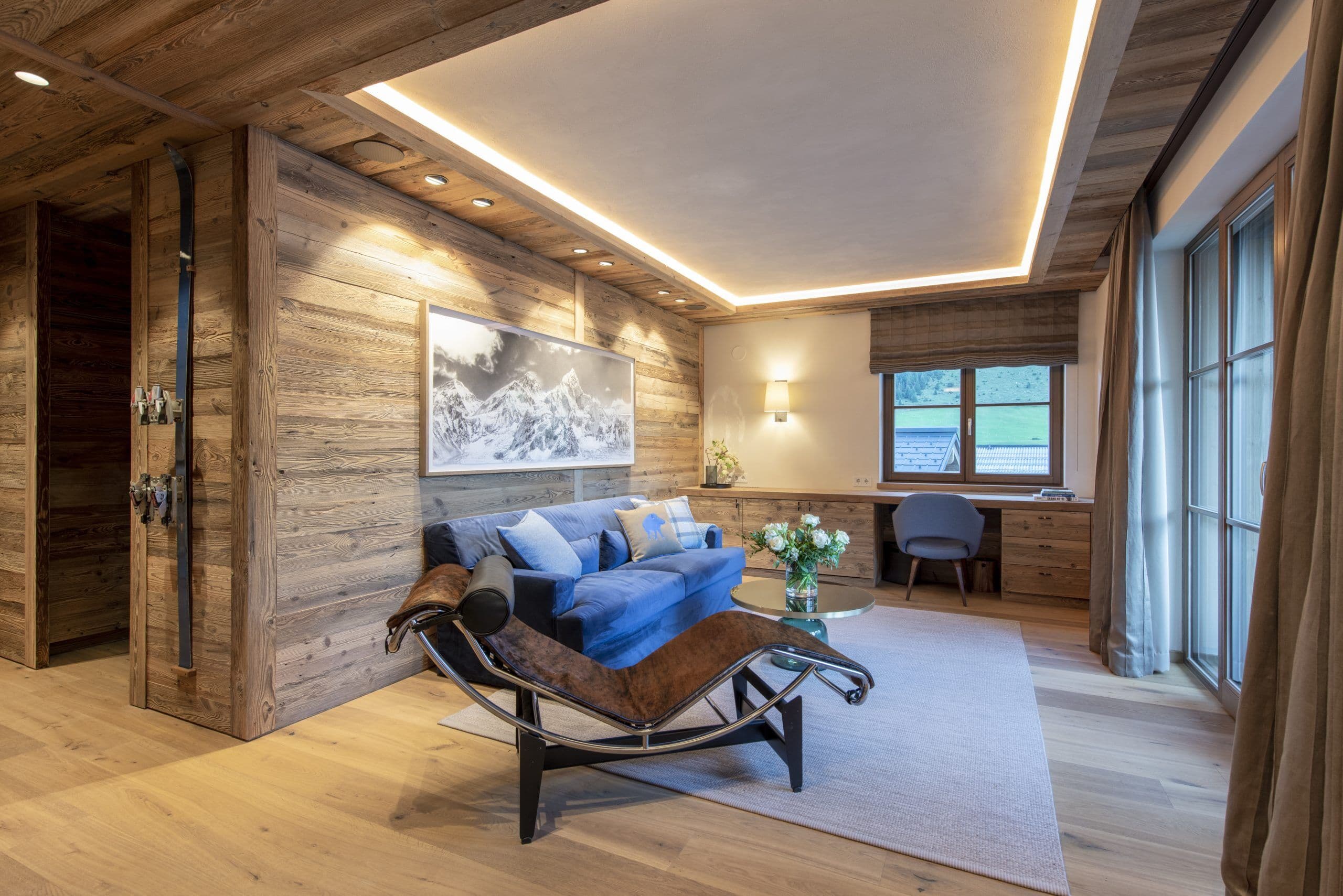 Chalech S master bedroom with natural wood walls and lounge seating, Lech, Austrian Alps, Austria