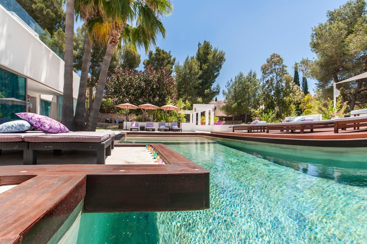 Vibrant Vinyasa infinity pool with wooden deck and loungers, Santa Eulària des Riu, Spain