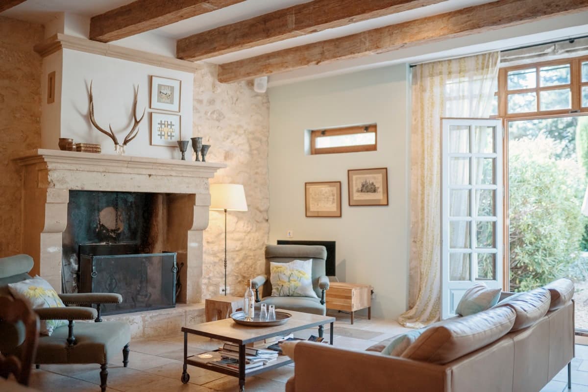 The French Effect living room with stone fireplace and beams, Maussane-les-Alpilles, France