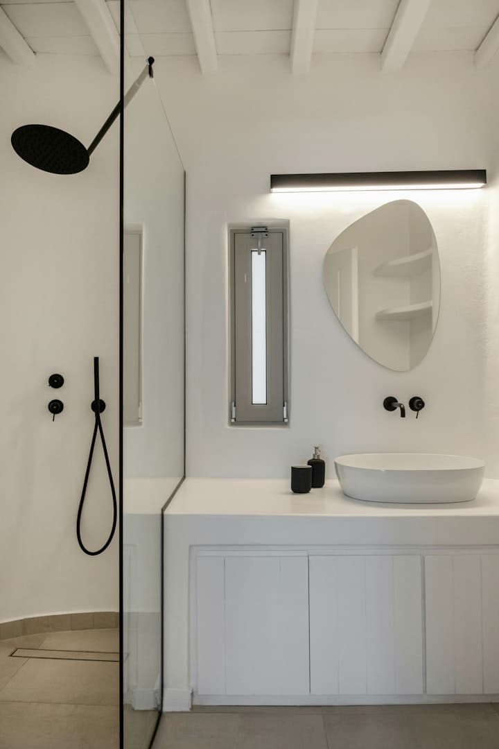 Island Azure Haven ensuite bathroom with black fixtures and organic mirror, Mykonos, Greece