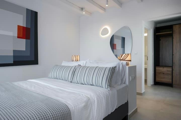 Island Azure Haven master bedroom with contemporary art and circular mirror, Mykonos, Greece